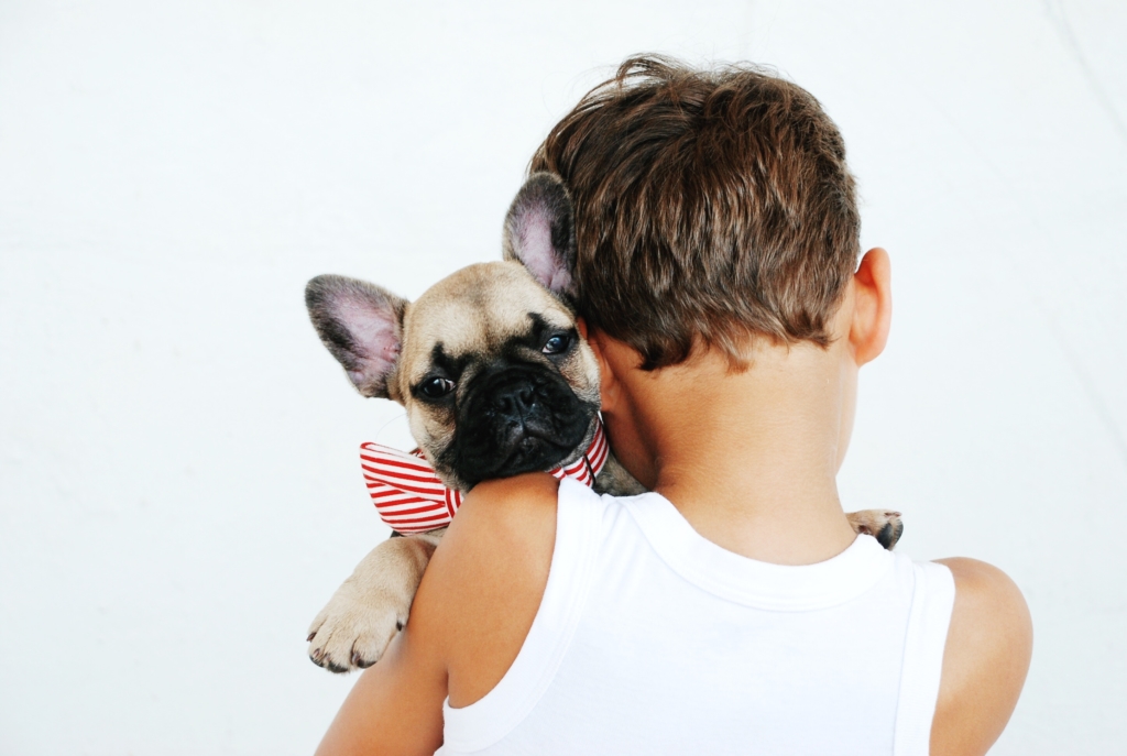 Boy cuddling with emotional support dog. 