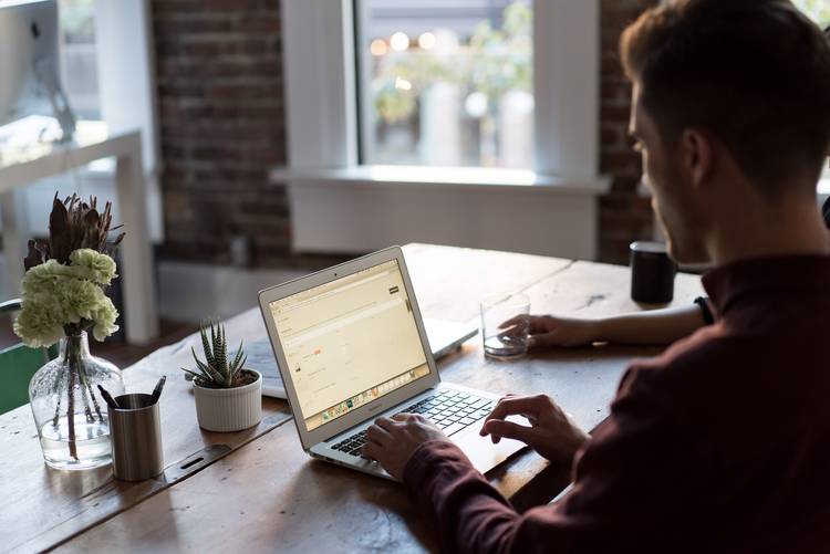 Man on laptop online applying for an Emotional Support Animal - ESA Doctors